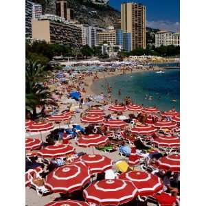 Overhead of Red Sun Umbrellas at Larvotto Beach on Busy Summers Day 